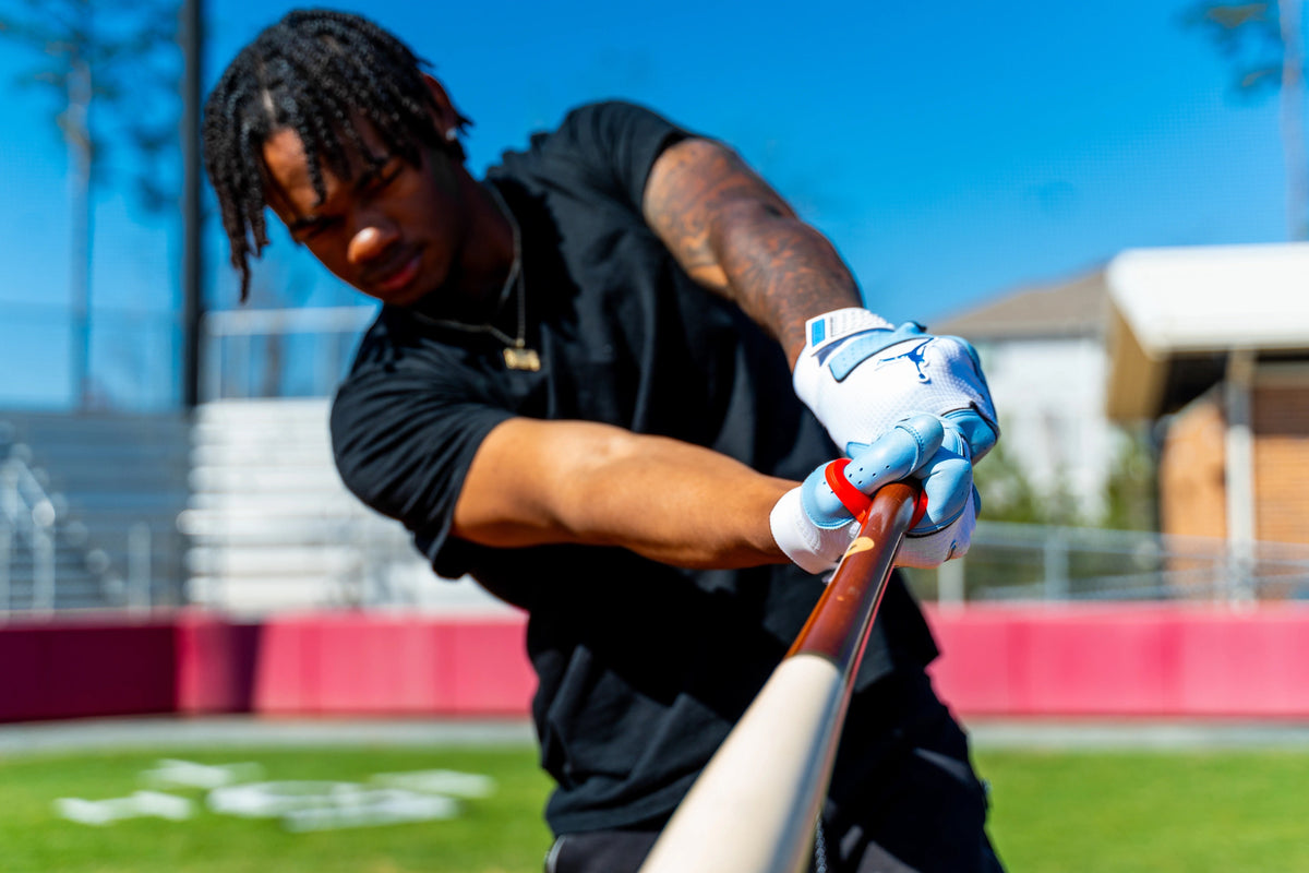 Player mid-swing gripping the bat with Hit Hero at the point of contact