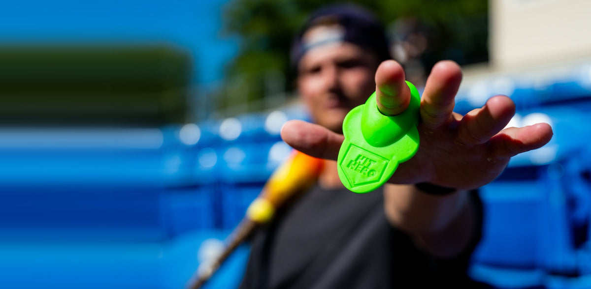 Player reaching toward the camera wearing a green Hit Hero guard